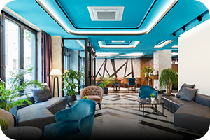 MTF Shop Samsung Klimaanlage Wärmepumpe Österreich | Eine elegante Lounge mit blauer Decke und einer zentral installierten Samsung WindFree Kassette. Das FJM Multi-Split-System ermöglicht den Anschluss mehrerer Innengeräte an nur ein Außengerät für individuellen Klimakomfort.