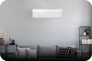 MTF Shop Samsung Klimaanlage Wärmepumpe Österreich | Ein modernes Wohnzimmer mit einem dezent an der grauen Wand montierten Samsung WindFree Wandgerät. Die Single-Split-Anlage ist die ideale Lösung für effiziente, zugfreie Kühlung und Heizung einzelner Wohnräume.