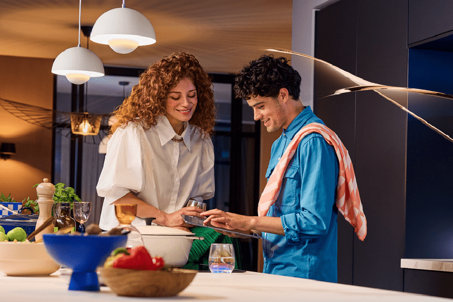 MTF Shop Samsung Klimaanlage Wärmepumpe Österreich | Ein Paar nutzt die SmartThings App in der Küche, um die Raumtemperatur komfortabel zu steuern. Intelligente Vernetzung für ein effizientes und modernes Zuhause.